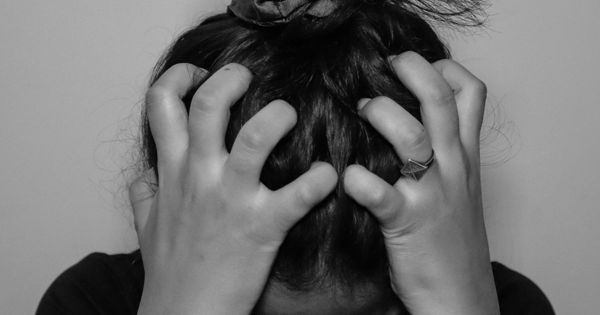 Tired mum holding her head, mum rage and mom rage